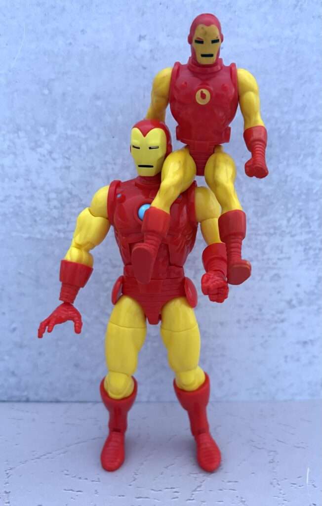 Hasbro Pulse's Secret Wars Iron Man figure holding up an original Mattel Secret Wars Iron Man figure