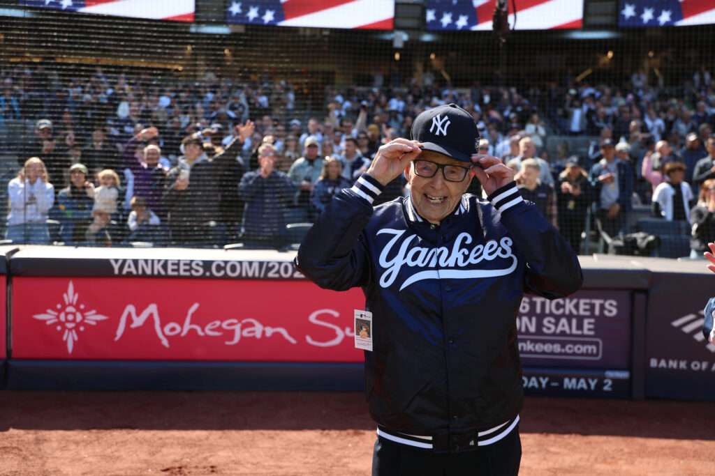 Phil Thau adjusts his Yankees cap on the field of Yankee Stadium