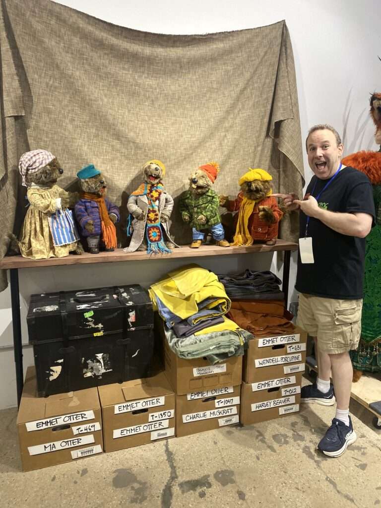 Andrew standing in front of Jim Henson's Emmet Otter Jugband puppets