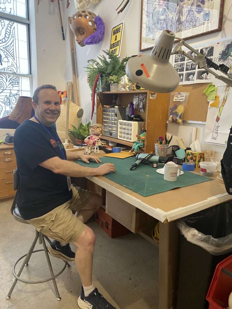 Andrew at a puppet desk at Jim Henson's Creature Shop 